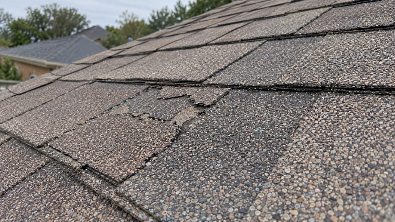1793459445846 Fractured and intact composition shingles side by side Fractured and intact composition shingles side by side