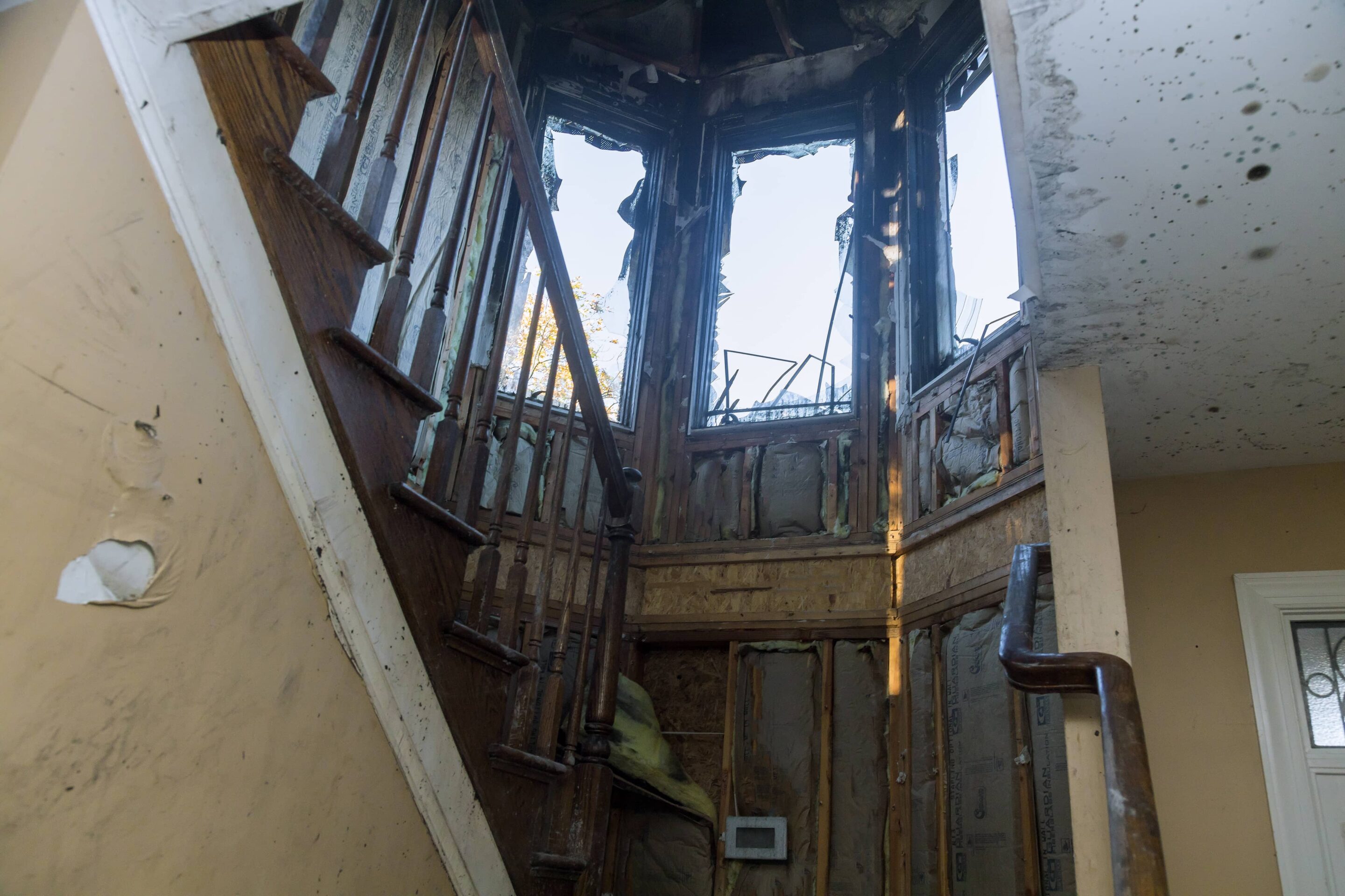 Fire damage restoration specialist reviewing damage with homeowners during a post-fire property inspection